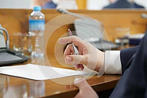 Hand of an adult male in a business suit holding a fountain pen. Analyzing a paper document. Lawyer, official, businessman, deputy