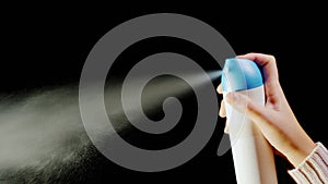 Hand with an aerosol can. Spray spray on a black background photo
