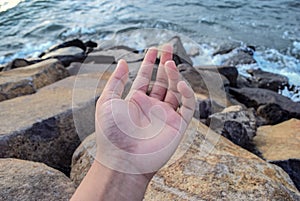 Hand, air, ocean , and stone photo