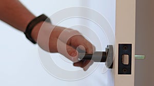 Hand with alarm open wooden door. Close up