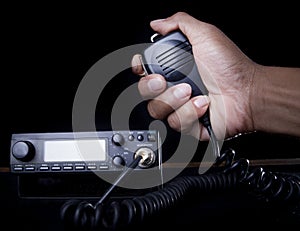 Hand of Amateur radio holding speaker and press photo