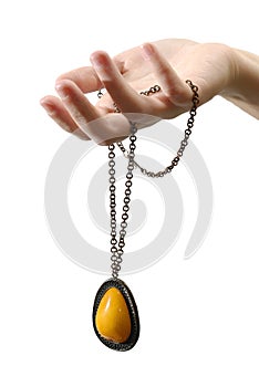 A hand with an amber pendant isolated