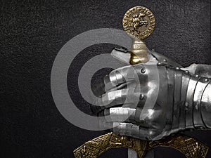 A hand in an ancient knight`s glove.