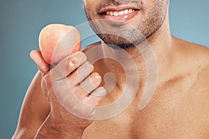 Hand, apple and beauty with a man model in studio on a blue background for heathy eating or diet. Food, fruit and health