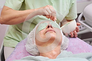 Hand applying alginate face mask.