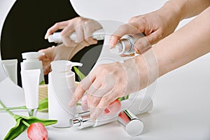 Hand applying natural skincare, Cosmetic bottle containers packaging with tulip flower essence