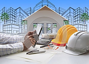 Hand of architect working on computer tablet with construction