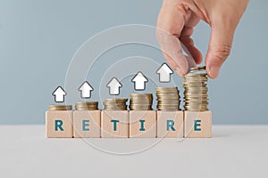 Hand arrange stack of coins on wooded cube blocks. For money saving for retirement,.planning of saving ,investment after retire