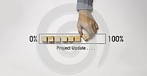 Hand arrange wooden block cube download bar from 0% to 100% for project update progress concept