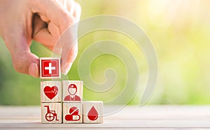 Hand arranged wooden blocks with icons of medical health. health insurance for your health concept