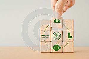 hand arranged wooden cube blocks with safety at workplace icon for safe for work concept, Employees safety awareness at workplace