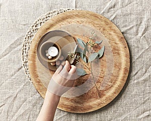 Hand arranging a candle and simple decor with leaves