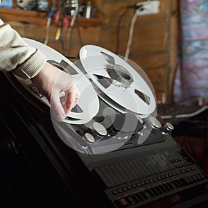 Hand arranging a tape in a reel-to-reel recorder