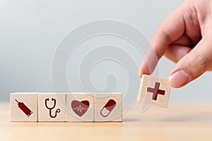Hand arranging wood block cube shape with icon healthcare medical