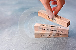 Hand arranging wood block with monthes. photo