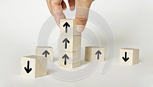 Hand arranging wood block stacking as step stair with arrow up. Ladder career path concept for business growth success process