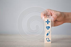 Hand arranging wood block stacking with icon healthcare medical