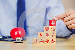 Hand arranging wood block stacking with icon healthcare medical