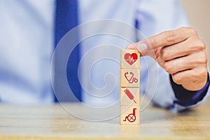 Hand arranging wood block stacking with icon healthcare medical