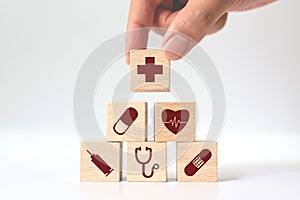 Hand arranging wood block stacking with icon healthcare medical