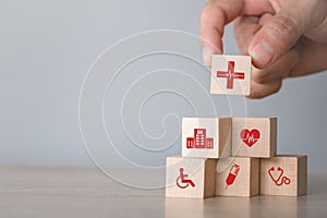 Hand arranging wood block stacking with icon healthcare medical