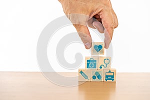 Hand arranging wood block stacking with the medical icon for healthcare and Health insurance management concept