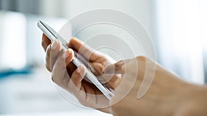 Hand of Asian girl using texting mobile phone or chat. Close up of woman hand