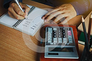 Hand Asian man calculate finances and accounting for monthly expenses / charges or cost photo