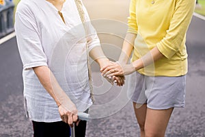 Hand of asian woman holding one`s hands elderly while walking at outdoor,Ederly taking care concept