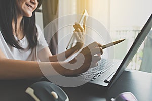 Hand of asian woman using tablet with pen pointing to laptop serching for online shopping concept