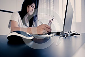 Hand of asian woman using tablet with pen pointing to laptop serching for online shopping concept