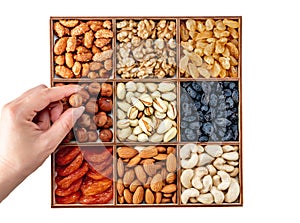 Hand with assorted nuts and dried fruit collection. Different superfoods. Vegetarian snack of different nuts. organic mixed nuts