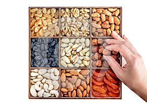 Hand with assorted nuts and dried fruit collection. Different superfoods. Vegetarian snack of different nuts. organic mixed nuts