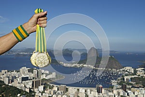 Hand of Athlete Holding Gold Medals Rio Skyline