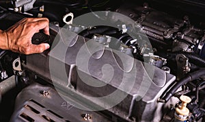 Hand of auto mechanic technician service engine and open the engine oil lid