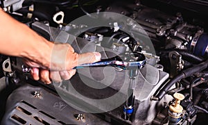 Hand of auto mechanic technician service engine and using wrench socket