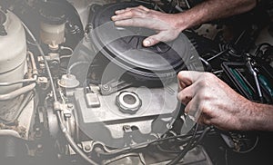 Hand of auto mechanic with a wrench.