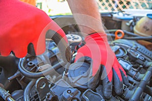 Hand of auto mechanic with a wrench. Engine repair. Checking of a car performance in car-care service