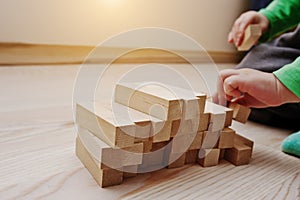 Hand of baby who played developmental game of wooden blocks