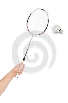 Hand with badminton racket and feather shuttlecock