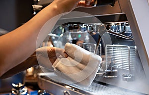 Hand of barista cleaning milk frother of coffee machine to be ready for milk frothing