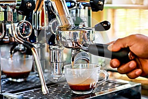 Hand of Barista making espresso coffee with the coffee machine in the coffee shop or cafe, Foods and drink concept