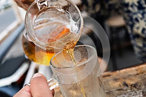 Hand of bartender pouring beer to glass