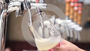 Hand of bartender pouring a large glass of lager beer with tap. Beer degustation. Concept of alcohol drink