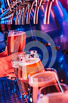 Hand of bartender pouring a large lager beer in tap