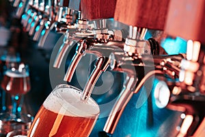 Hand of bartender pouring a large lager beer in tap