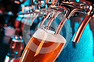 Hand of bartender pouring a large lager beer in tap