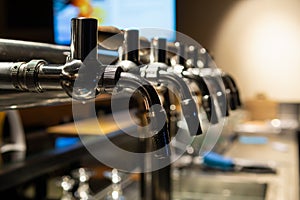 Hand of bartender pouring a large lager beer in tap. Rest in a bar with friends