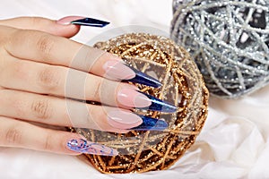 Hand with beautiful long artificial blue french manicured nails