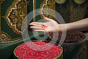 Hand of a beautiful woman in a store selling spices enjoying the same in the Jemaa el Fna square in the city of Marrakech in